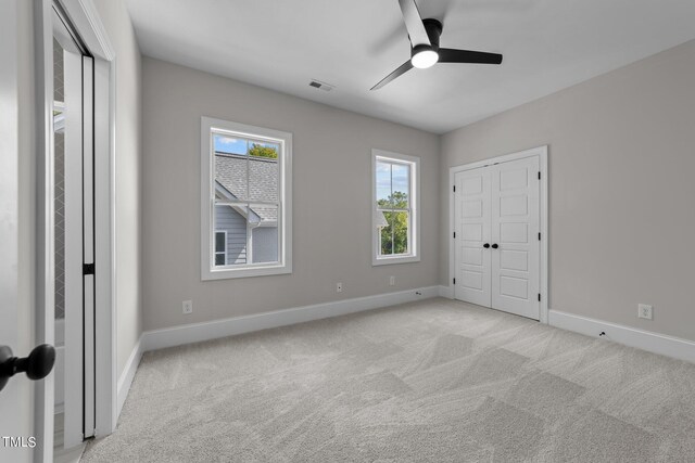 spare room featuring light carpet and ceiling fan