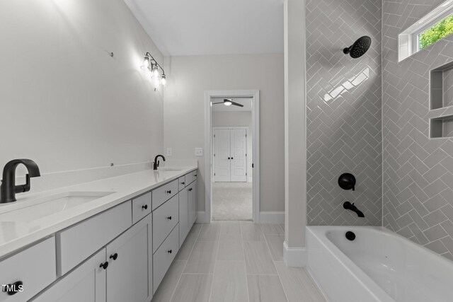 bathroom with tiled shower / bath combo, vanity, and tile patterned floors