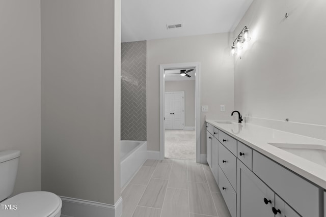 bathroom with vanity, tile patterned flooring, toilet, and a bath