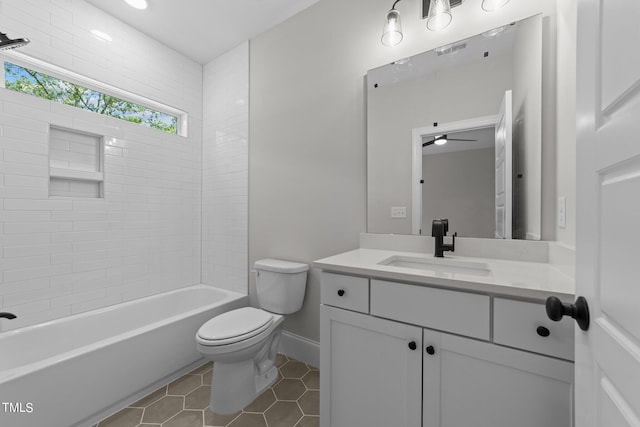 full bathroom with tiled shower / bath, vanity, ceiling fan, toilet, and tile patterned floors