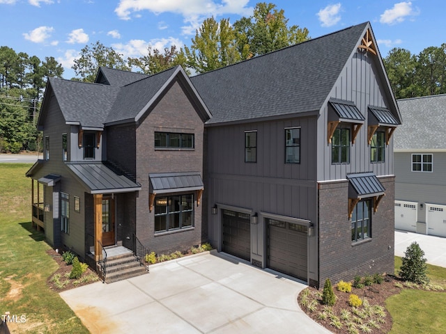 modern farmhouse style home featuring a garage and a front lawn