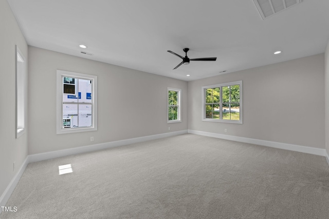 spare room with ceiling fan and light carpet