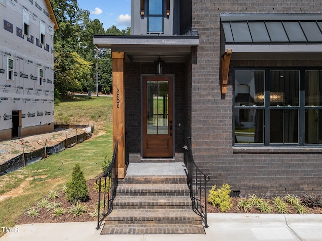 property entrance with a lawn