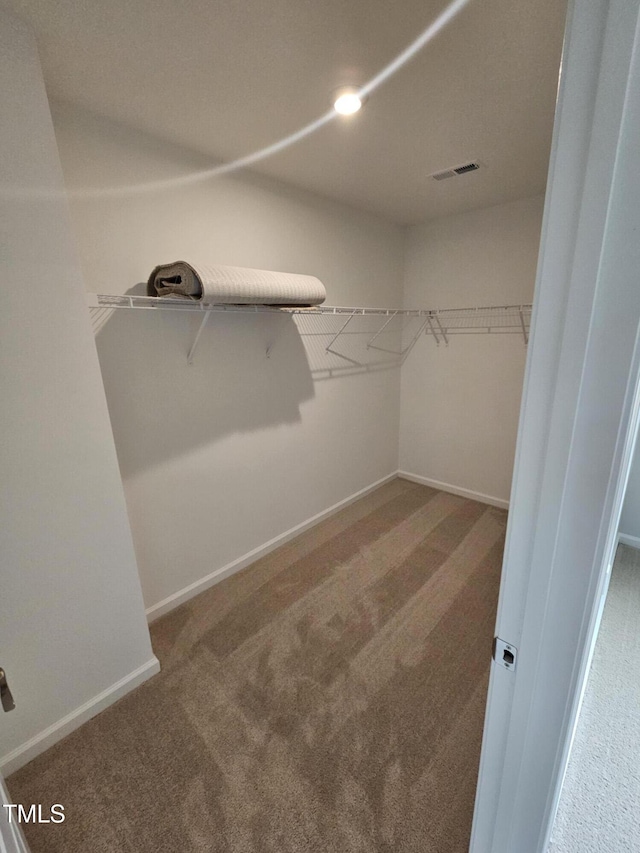 walk in closet featuring visible vents and carpet flooring