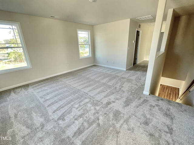 carpeted empty room featuring a wealth of natural light