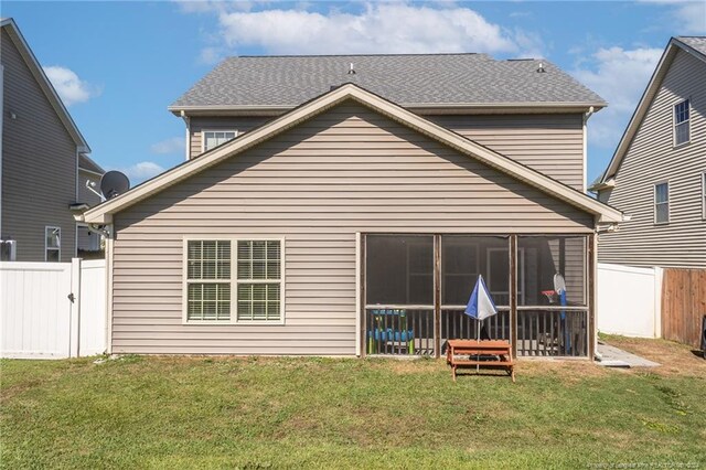 rear view of house with a yard and a sunroom