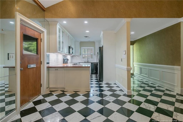 kitchen featuring white cabinets, ornamental molding, tasteful backsplash, appliances with stainless steel finishes, and wood counters