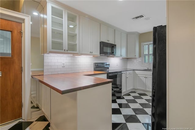 2116 Winterlochen Rd, Fayetteville, NC 28305 - kitchen with backsplash, a peninsula, glass insert cabinets, black appliances, and dark floors