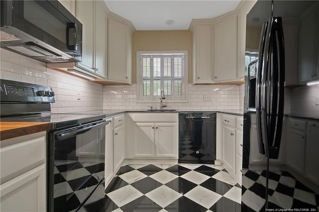 kitchen featuring black appliances, butcher block countertops, sink, and backsplash