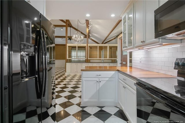 kitchen with white cabinets, vaulted ceiling, wood counters, and black appliances