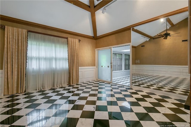 empty room featuring a wealth of natural light, beam ceiling, and ceiling fan