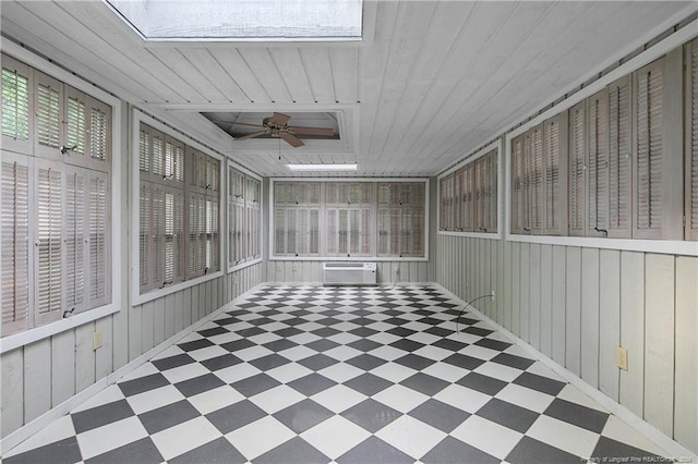 unfurnished sunroom featuring a skylight, wood ceiling, and a wall mounted air conditioner