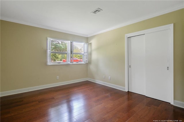 unfurnished bedroom featuring ornamental molding, dark hardwood / wood-style flooring, and a closet