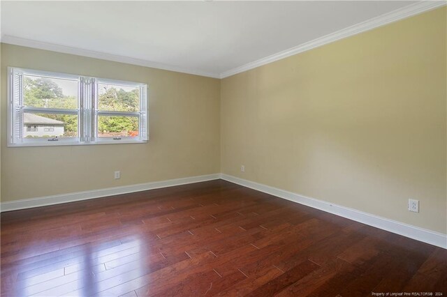 empty room featuring crown molding and dark hardwood / wood-style flooring