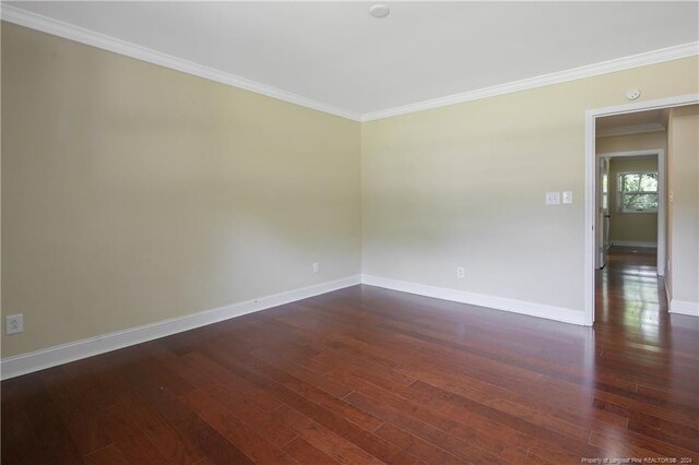 spare room with ornamental molding and dark hardwood / wood-style flooring