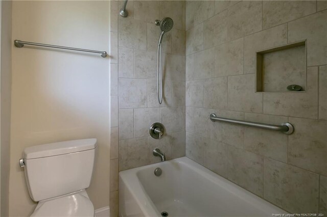 bathroom featuring tiled shower / bath and toilet