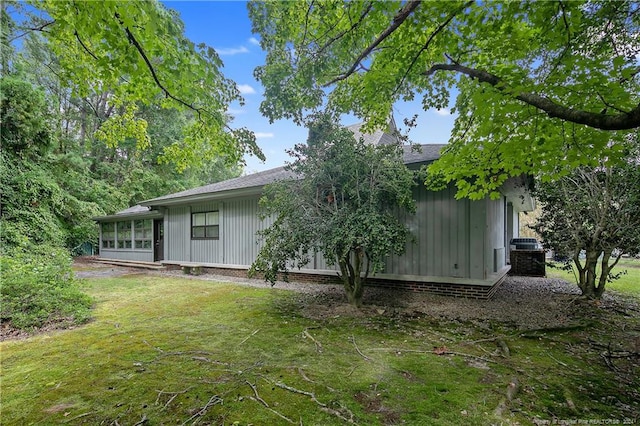 2116 Winterlochen Rd, Fayetteville, NC 28305 - back of property with a sunroom, board and batten siding, and a yard