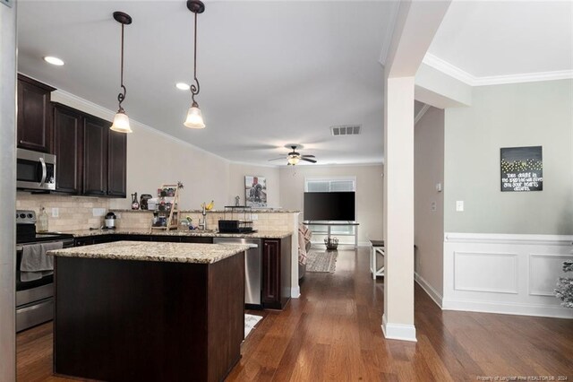 kitchen with dark hardwood / wood-style flooring, hanging light fixtures, stainless steel appliances, a center island, and ceiling fan