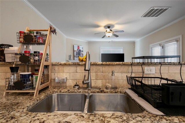 kitchen with crown molding, stone countertops, sink, and ceiling fan