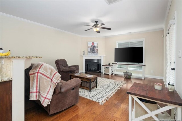 living room featuring ceiling fan, dark hardwood / wood-style floors, and ornamental molding