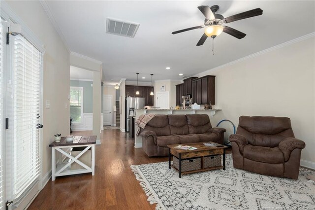 living room featuring ceiling fan, ornamental molding, and hardwood / wood-style floors