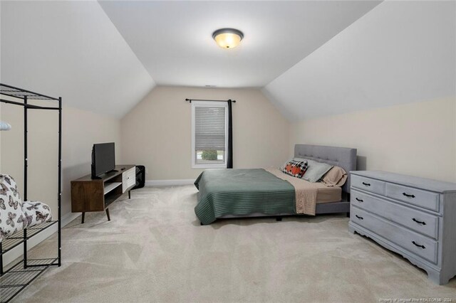 carpeted bedroom featuring lofted ceiling