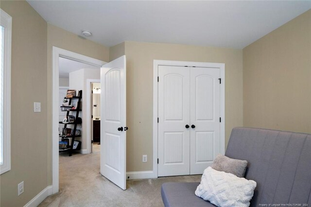 sitting room featuring light carpet