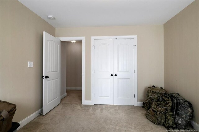 bedroom featuring light colored carpet and a closet