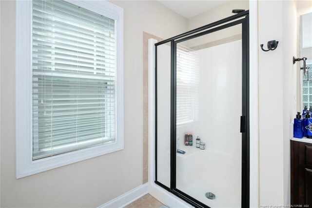 bathroom with walk in shower, vanity, and a healthy amount of sunlight