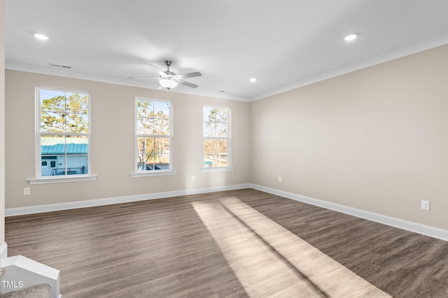 empty room featuring crown molding, dark hardwood / wood-style flooring, and plenty of natural light