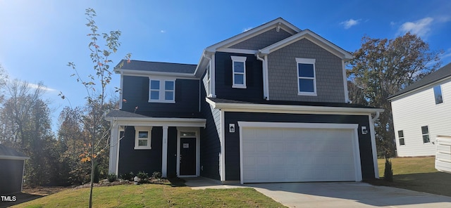 view of front of home with a garage, driveway, and a front lawn