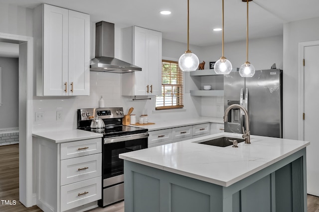 kitchen featuring light hardwood / wood-style flooring, stainless steel appliances, sink, wall chimney range hood, and a kitchen island with sink