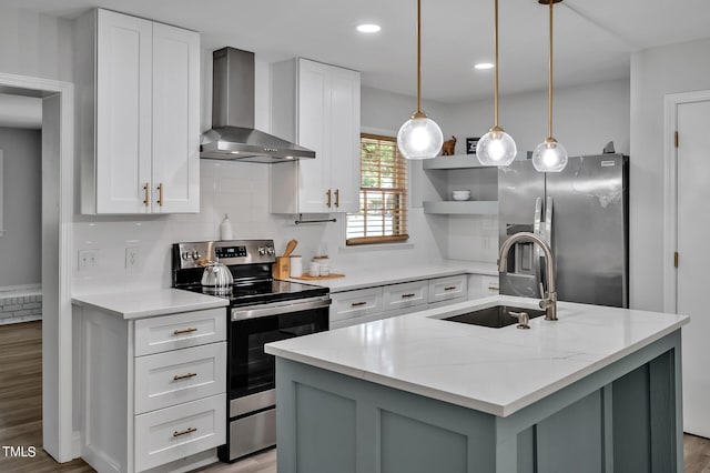 kitchen featuring stainless steel appliances, a sink, light wood-style floors, wall chimney range hood, and backsplash