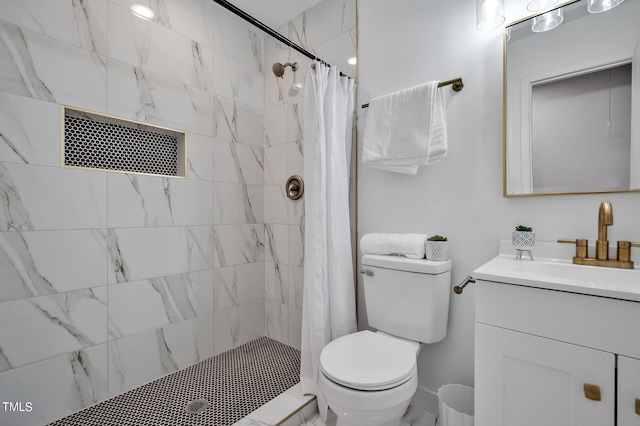 full bathroom featuring tiled shower, vanity, and toilet