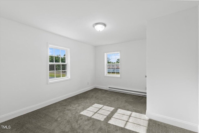 carpeted spare room featuring baseboard heating