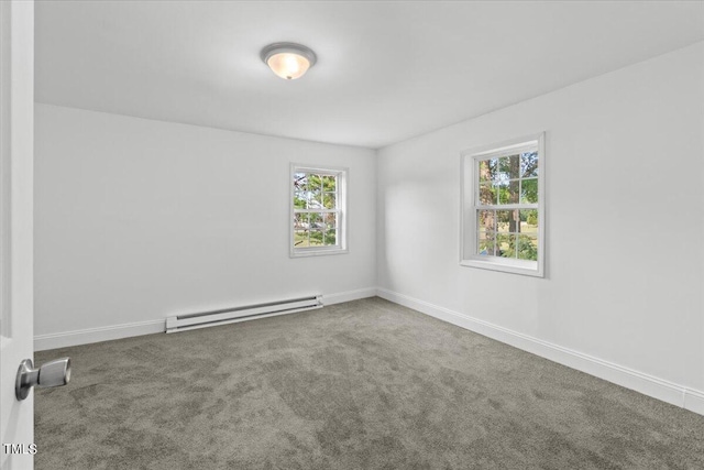 carpeted spare room featuring a baseboard heating unit