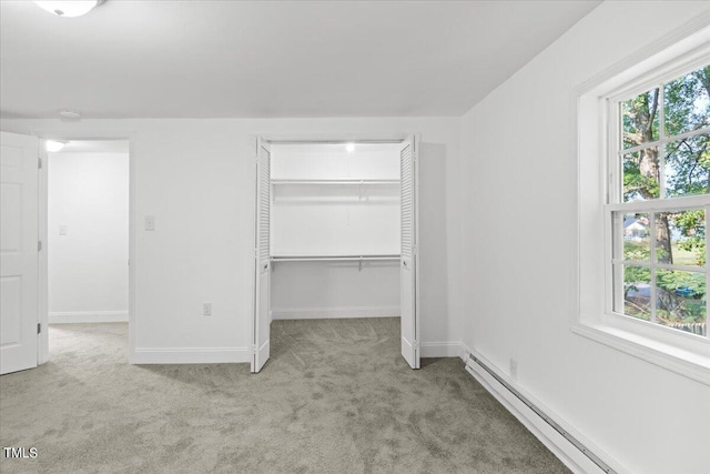 unfurnished bedroom featuring light colored carpet, baseboard heating, and multiple windows