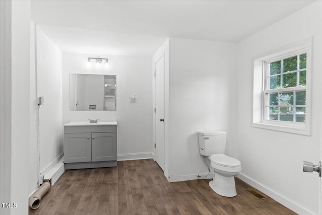 bathroom featuring vanity, toilet, and hardwood / wood-style flooring