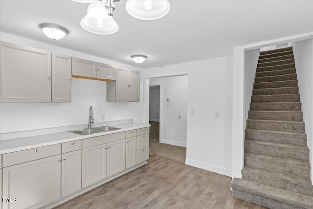 kitchen featuring gray cabinetry, sink, and light hardwood / wood-style floors