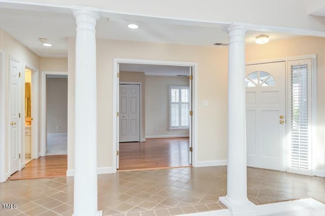 entrance foyer with decorative columns, light tile patterned flooring, visible vents, and baseboards