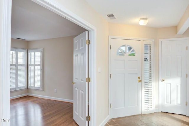 foyer entrance featuring light wood-style flooring, visible vents, and baseboards