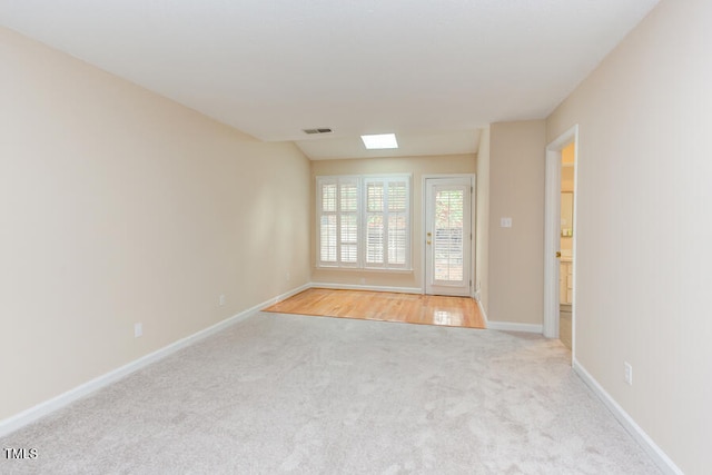 empty room with light carpet, visible vents, and baseboards