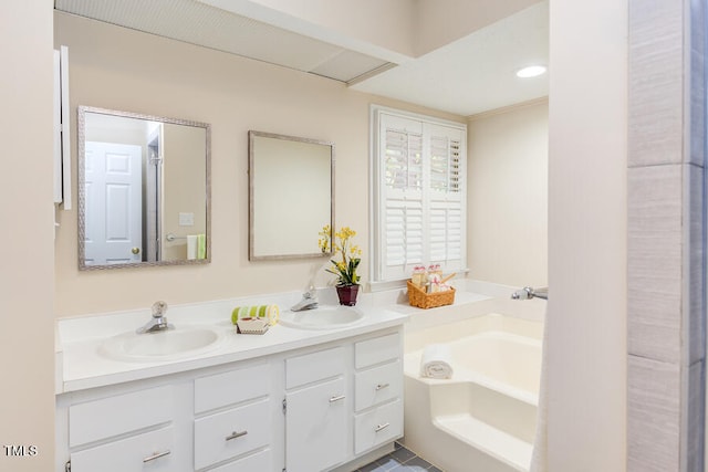 full bathroom with double vanity, a garden tub, and a sink