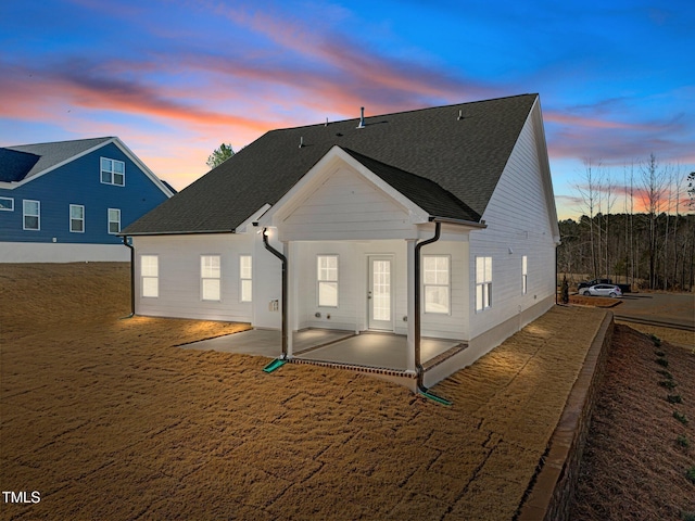 back house at dusk with a patio area