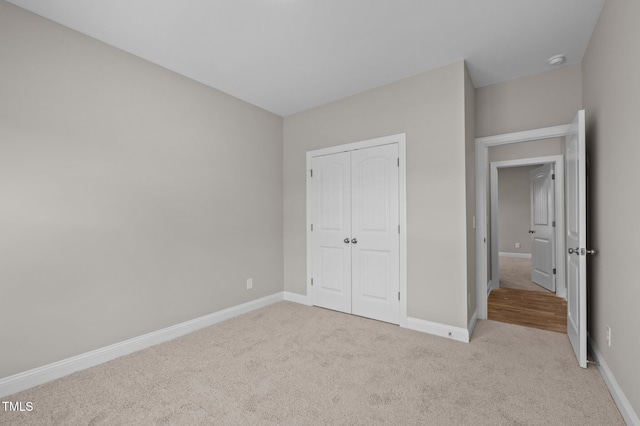 unfurnished bedroom with a closet and light carpet