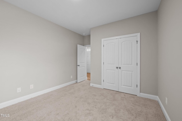 unfurnished bedroom featuring a closet and light carpet