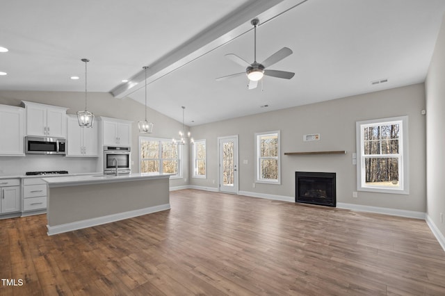 kitchen featuring pendant lighting, hardwood / wood-style flooring, an island with sink, and white cabinets