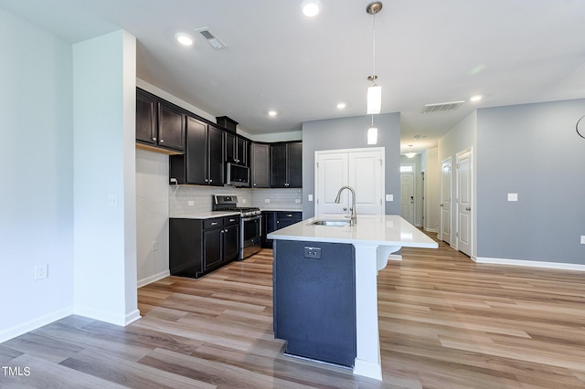 kitchen with stainless steel appliances, visible vents, a sink, and backsplash