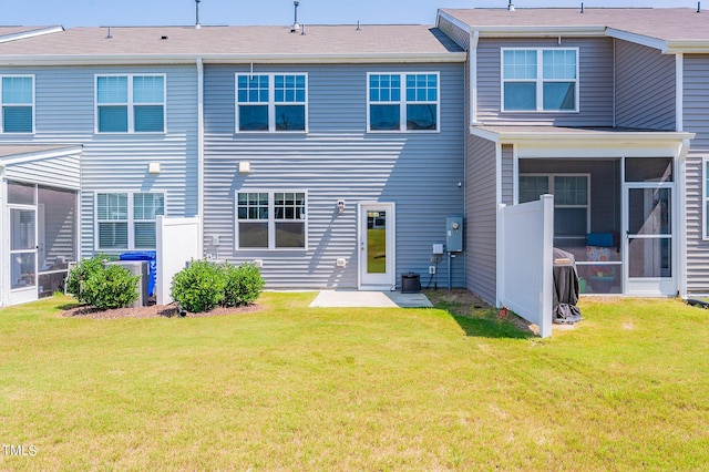 rear view of property with a sunroom and a lawn