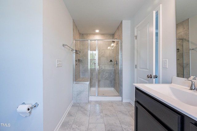 full bathroom featuring baseboards, a shower stall, and vanity